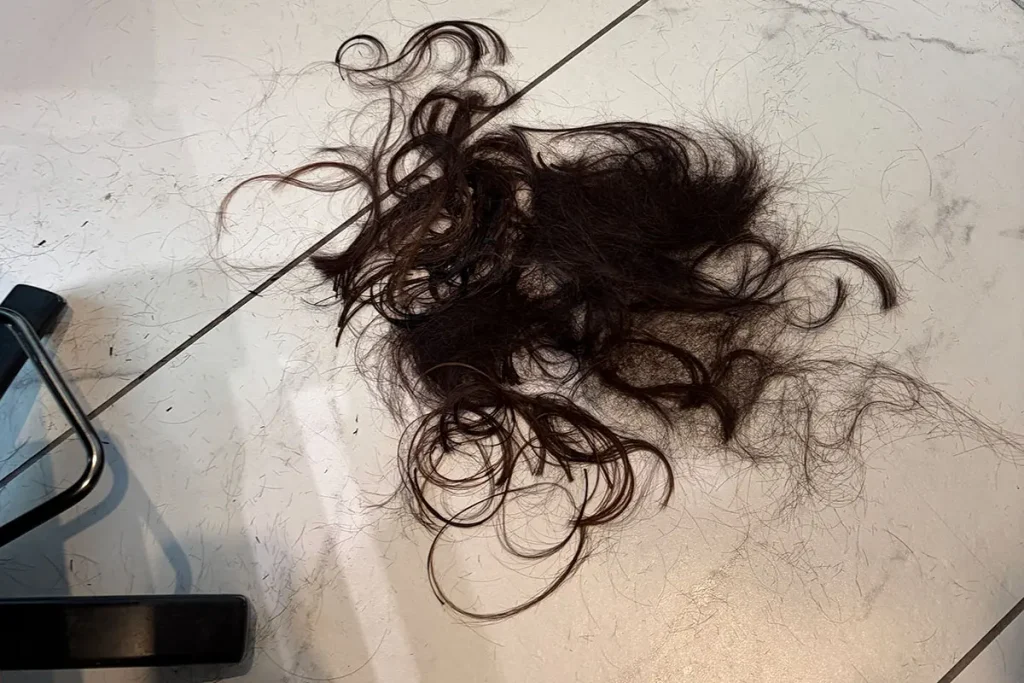 美容室の床に集められた、15cmほどバッサリとカットした髪の毛の山。長年のダメージ毛とおさらば。