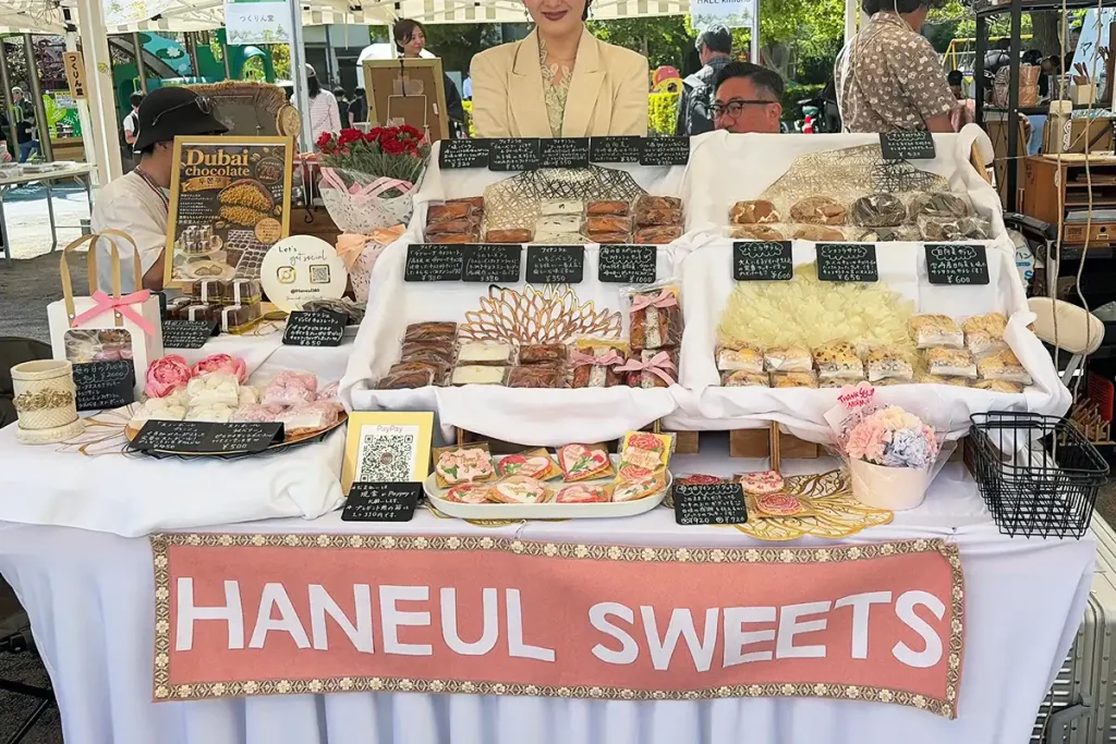 「HaneulSweets(ハヌルスィーツ)」の華やかな店頭。ピンクのロゴが入った看板と、綺麗にディスプレイされたフィナンシェやクッキー。