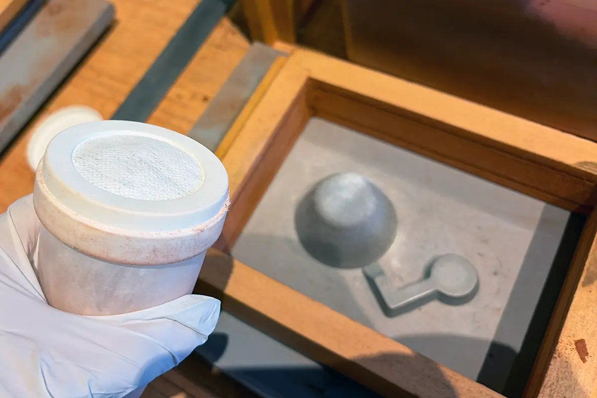 鋳型に白い離型用の粉を振る工程