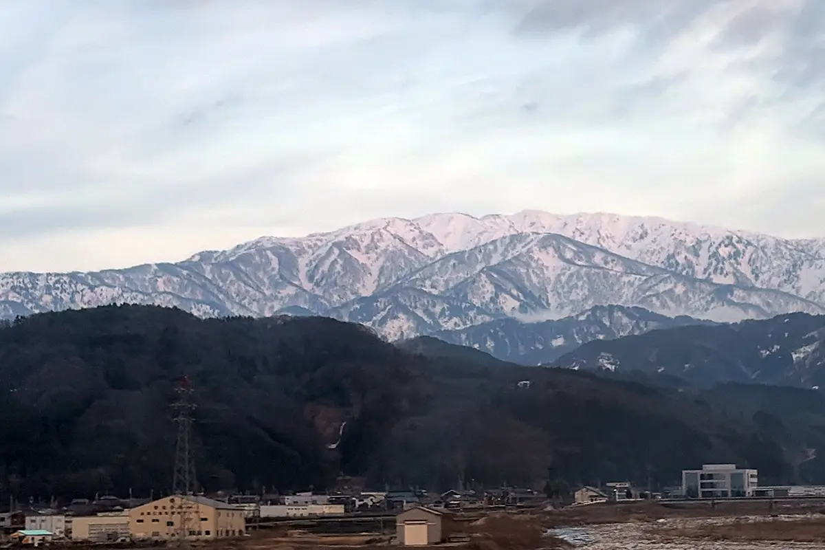 雪をかぶった立山連峰と富山の街並みの風景