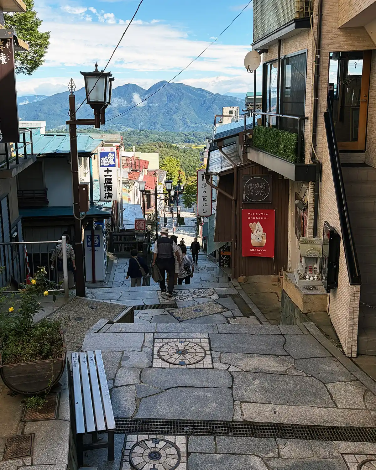 晴れた日の伊香保温泉石段街。石段の先に青空と山々が広がる景色