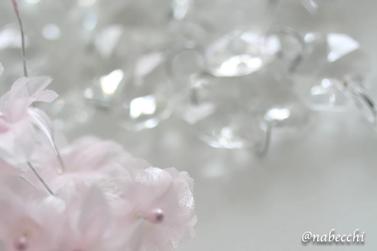 背景用に置いた造花と透明のロングネックレス