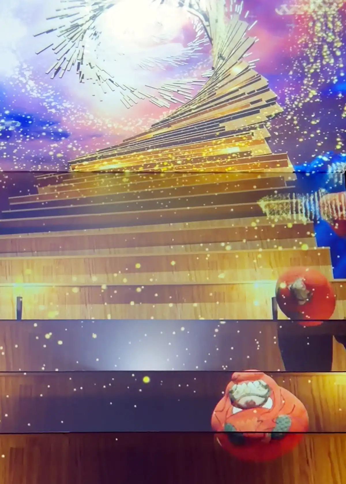 空へと伸びる階段から大量のだるまが降ってくるダイナミックな演出