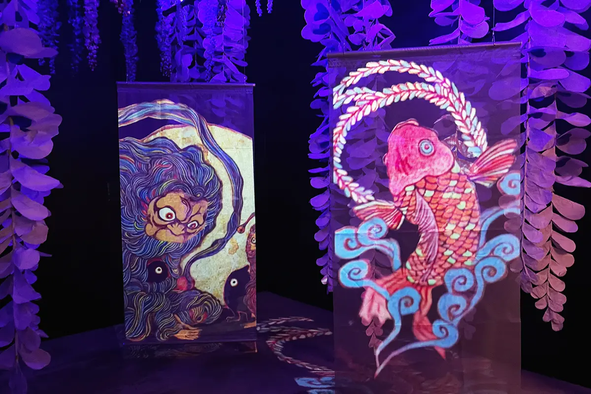 天井から垂れ下がる藤の花と、その間を浮遊する妖怪の巻物展示