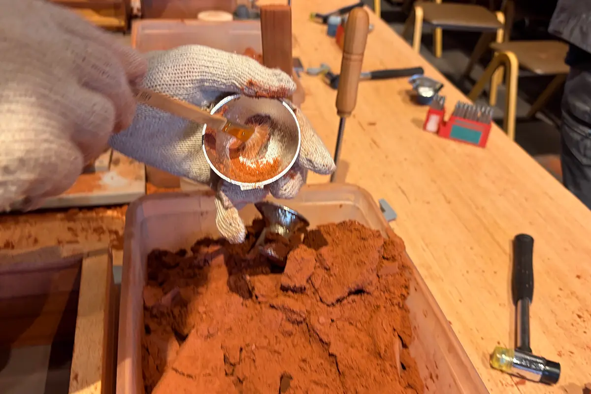 筆で砂を払い落とす工程