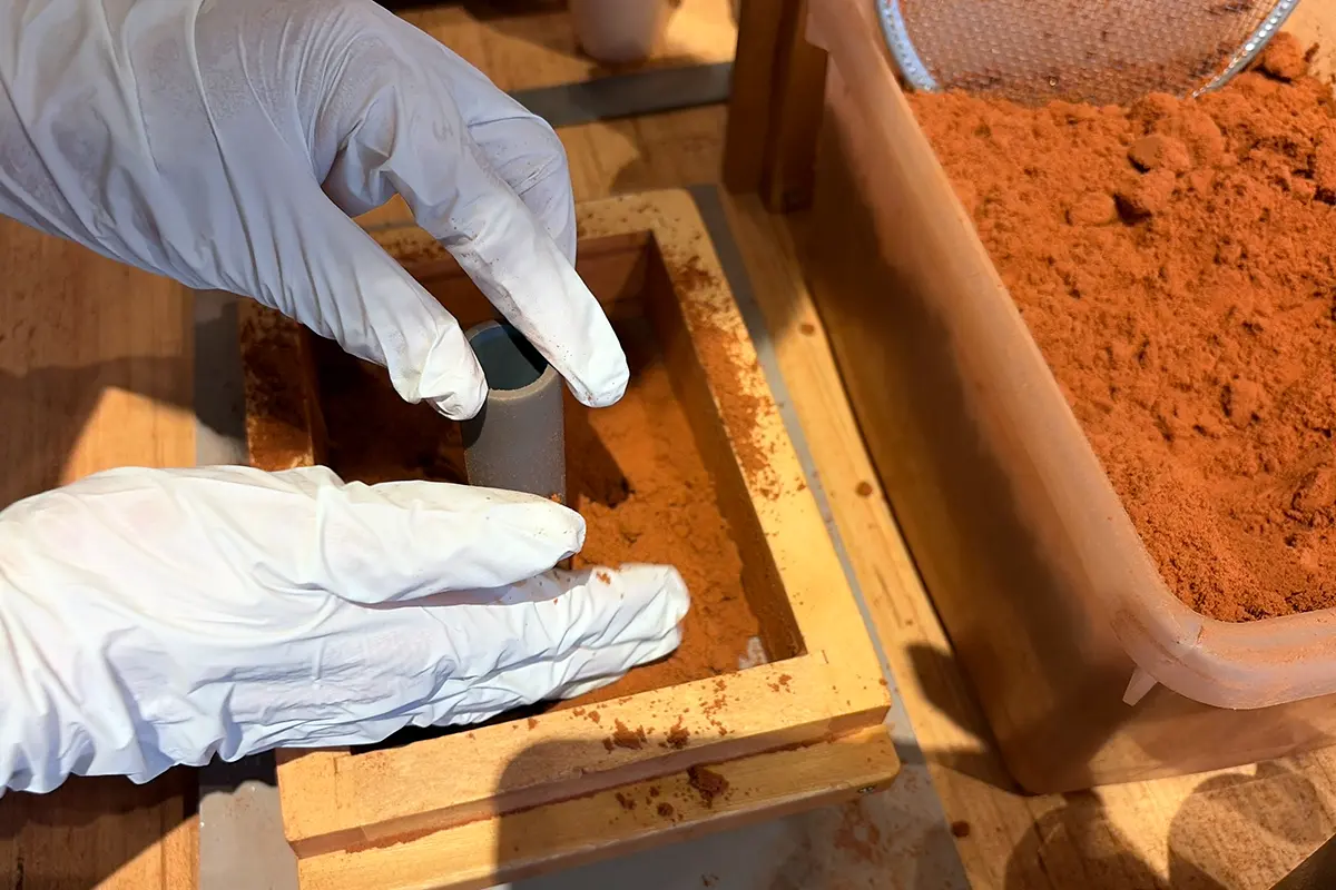 金属を流し込む湯口のパーツを設置する様子